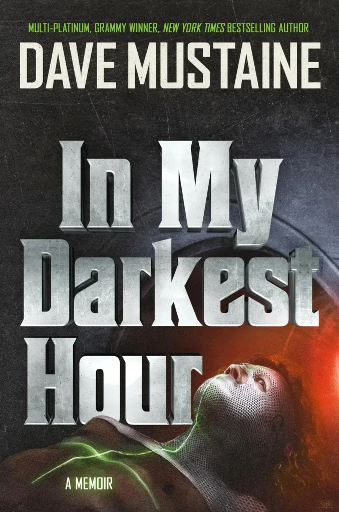 Cover of Dave Mustaine's memoir In My Darkest Hour, with large metallic title lettering above a figure in a mesh mask lying on a table