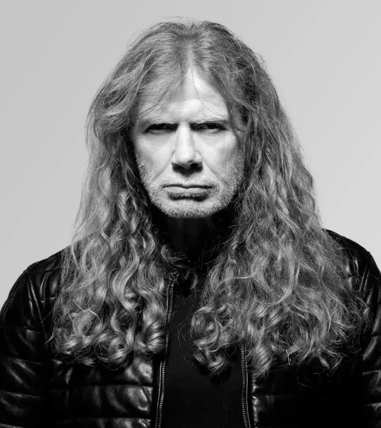 Black-and-white portrait of Dave Mustaine with long curly hair and a black leather jacket against a light grey background
