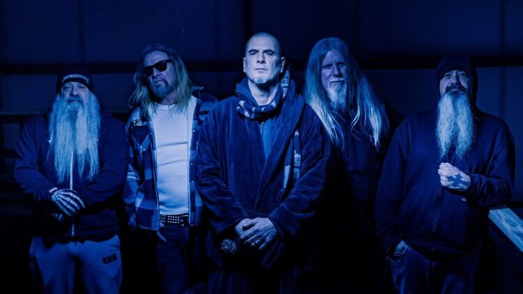 Down band members posing in dark clothing under deep blue lighting
