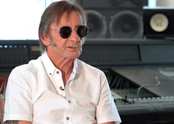 Phil Rudd in sunglasses and a white shirt during an interview in a recording studio