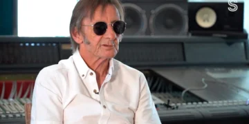 Phil Rudd in sunglasses and a white shirt during an interview in a recording studio