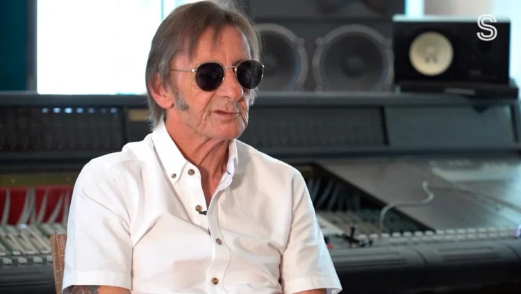 Phil Rudd in sunglasses and a white shirt during an interview in a recording studio